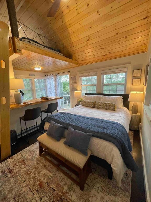 a bedroom with a large bed and a desk at Cheerful Cottage with Loft Close to Everything 6 in Edgecomb