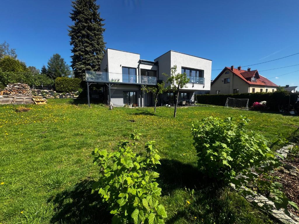 a house on a green lawn with a tree at Apartamenty Okrętowa 23 Bolek Lolek in Bielsko-Biala