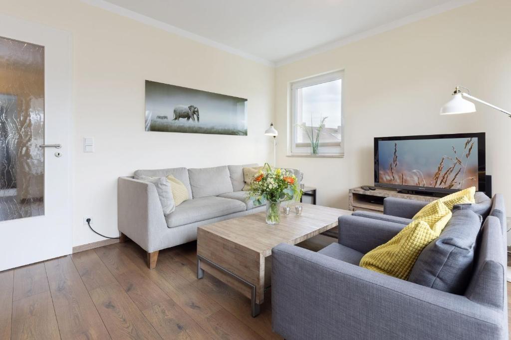 a living room with two couches and a tv at Baltic Sea Lodge Küstenidyll in Scharbeutz