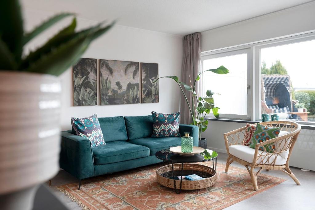 a living room with a blue couch and a chair at Strandbungalow Ostsee in Rettin