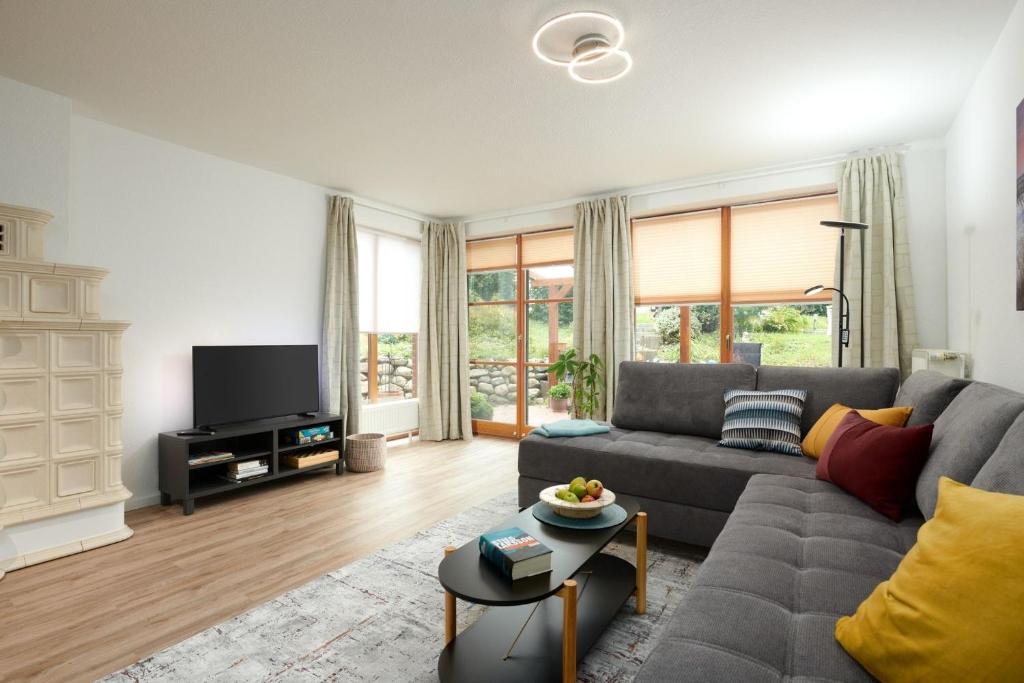 a living room with a couch and a tv at ToHuus in Laboe