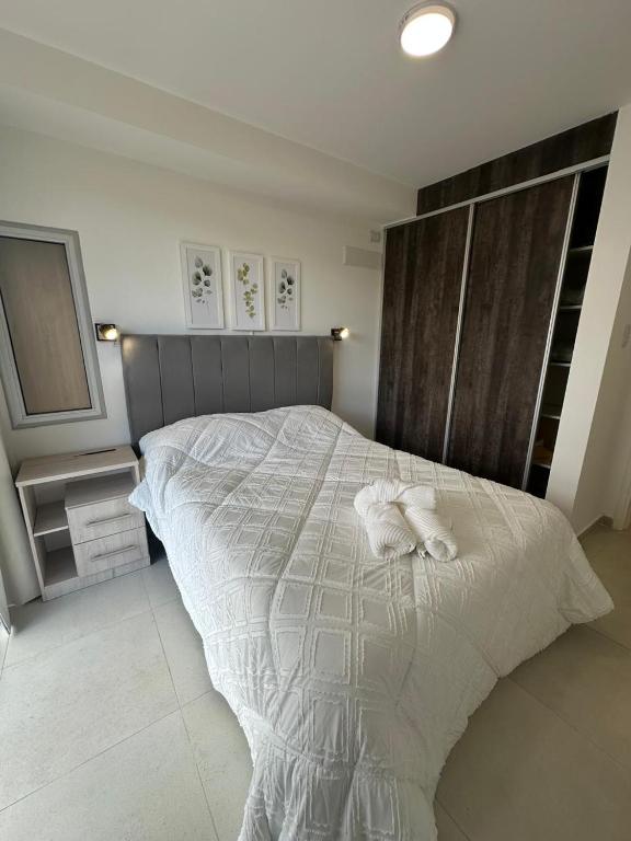 a bedroom with a large bed with white sheets at Dpto Villa María - Excelente Estadía in Villa María