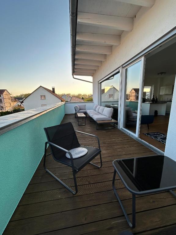 a balcony with chairs and a couch on a roof at Schwarzwald Lahr Europapark Penthouse Sunshine in Lahr