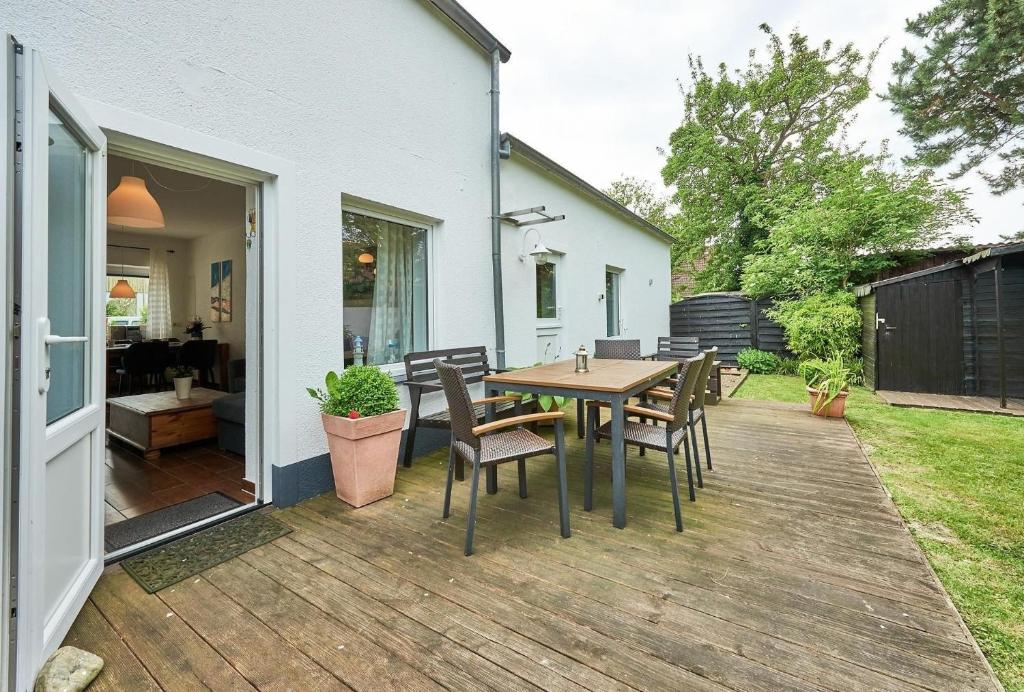 a patio with a table and chairs on a deck at Ferienbungalow LEO in Petersdorf auf Fehmarn