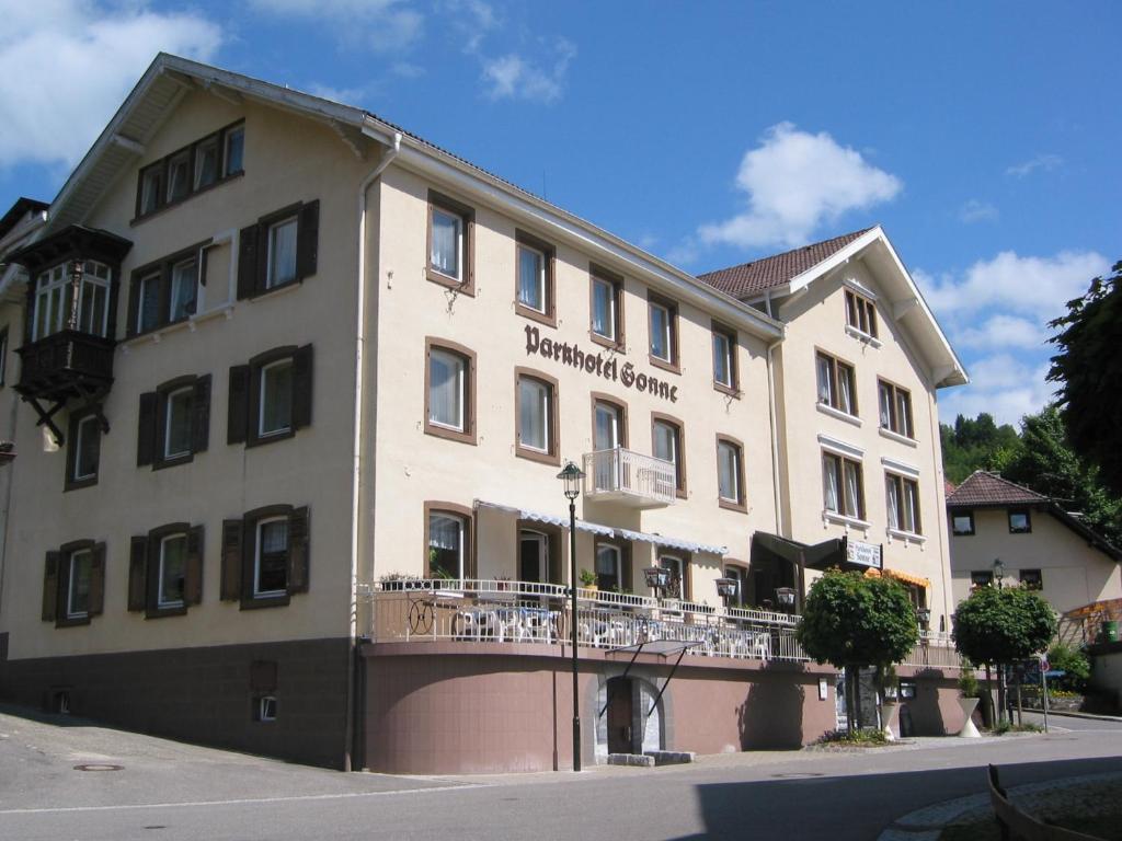 Großes weißes Gebäude mit Balkon in der Unterkunft Parkhotel Sonne in Schönau im Schwarzwald