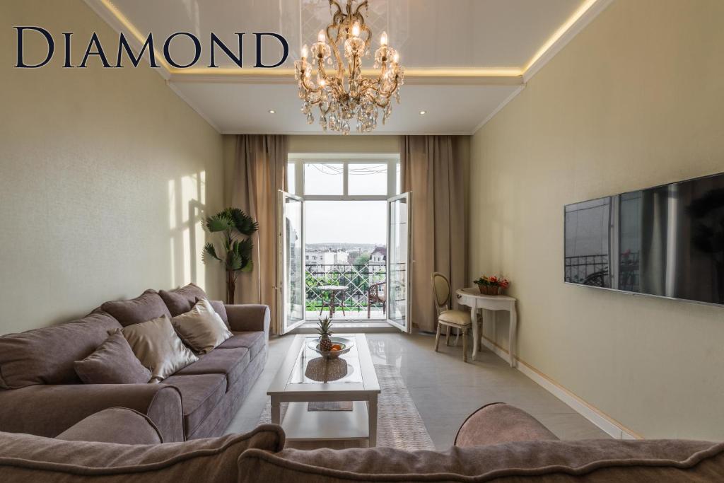 Una sala de estar con un sofá y una lámpara de araña. en Max Luxury Apartments, en Belgrado