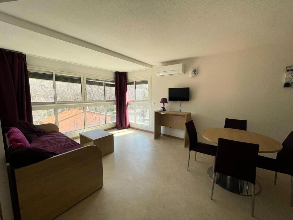 un salon avec un canapé et une table dans l'établissement Résidence Balcon Du Canigou - T2 dans la résidence Les Balcons du Canigou MAE-2761, à Vernet-les-Bains