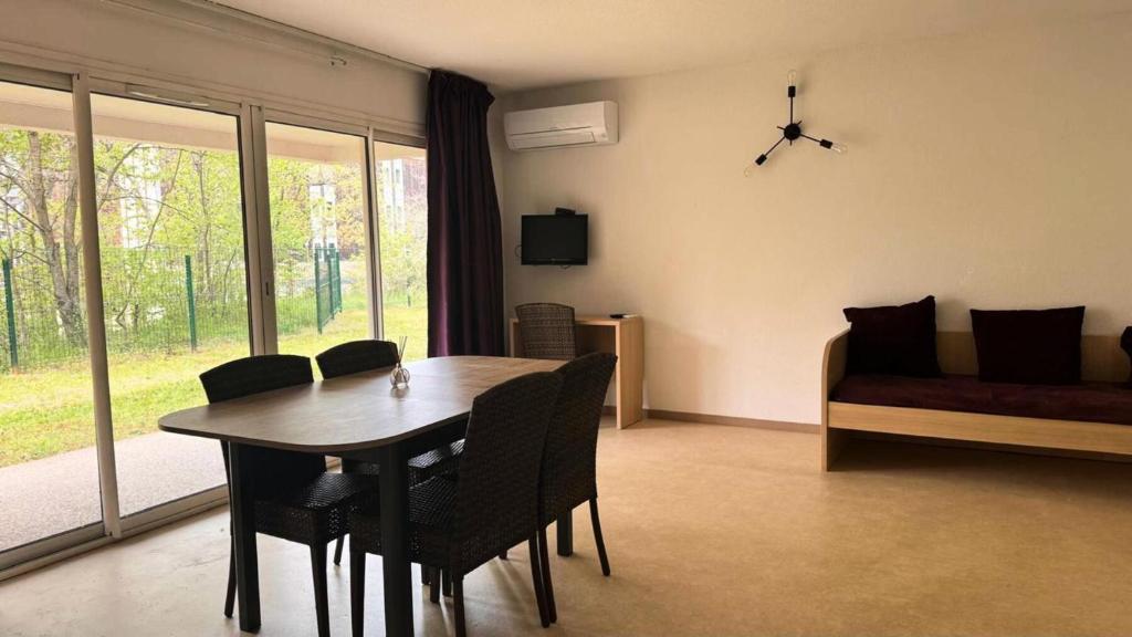 une salle à manger avec une table, des chaises et un canapé dans l'établissement Résidence Balcon Du Canigou - T3 dans la résidence Les Balcons du Canigou MAE-2791, à Vernet-les-Bains