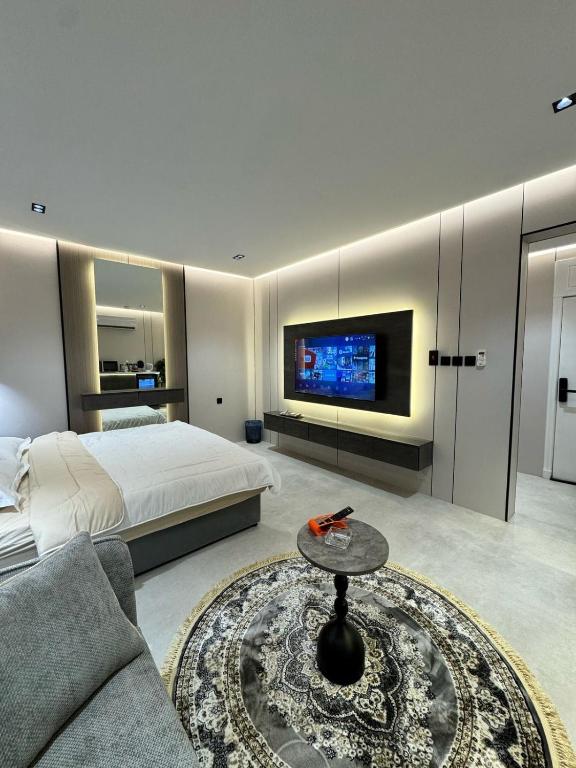 a bedroom with a bed and a tv on a wall at استديو فاخر بجلسه ودخول ذاتي in Al Hofuf