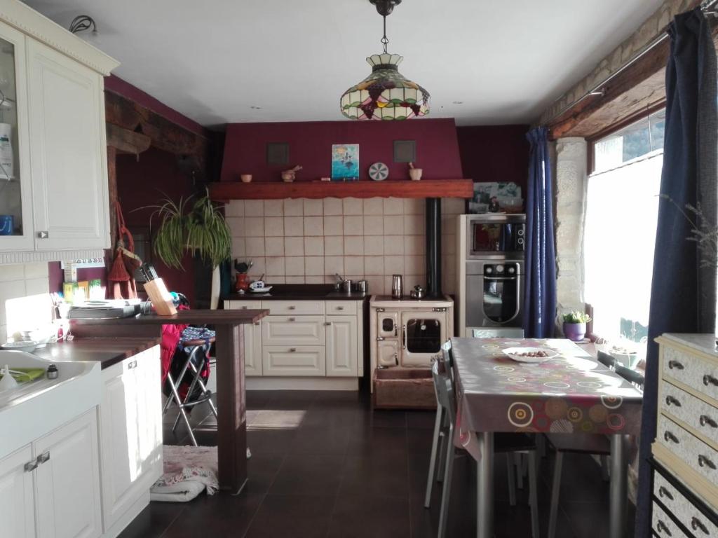 een keuken met witte kasten en een tafel. bij Casa rural Eguzkilore in Etuláin