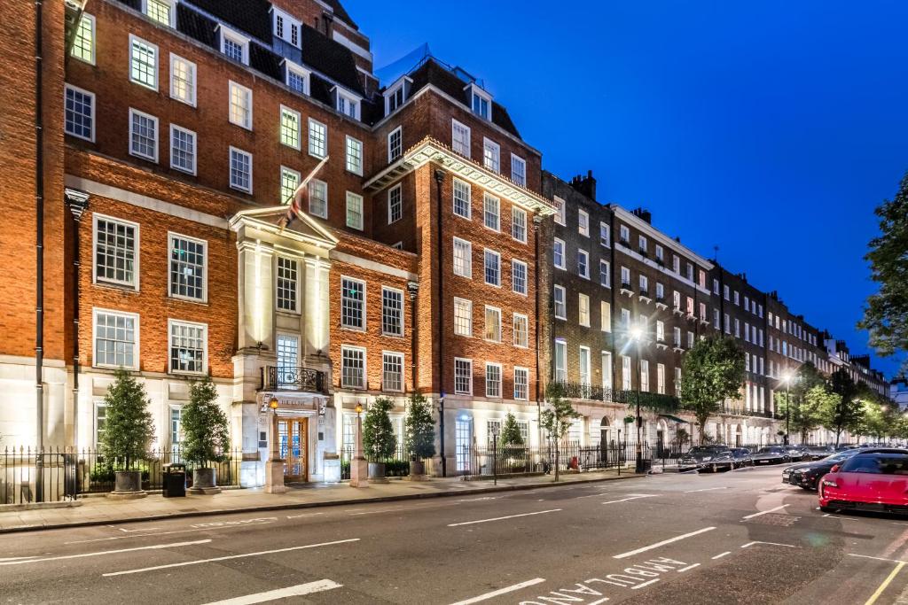 ロンドンにあるMajestic Luxury Apartment in Maryleboneの大きなレンガ造りの建物の前に停められた赤い車