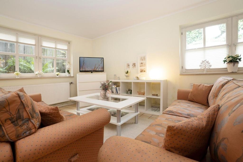 a living room with a couch and a table at Erlenstübchen in Scharbeutz