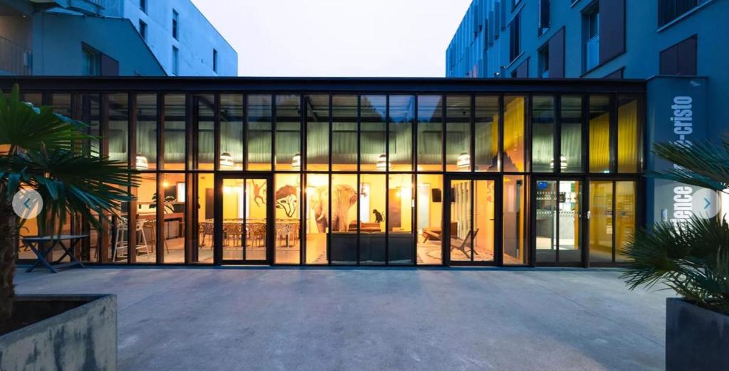 un bâtiment avec de grandes portes en verre dans une ville dans l'établissement Appartement 2 pièces entre centre ville et machine de l'île, à Nantes
