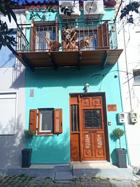 a blue building with a door and a balcony at Little Angelo's Cottage - Greek Summer Escape in Plomari