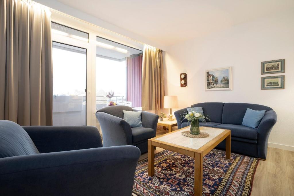 a living room with two blue couches and a table at Berolina Ostseegold in Dahme