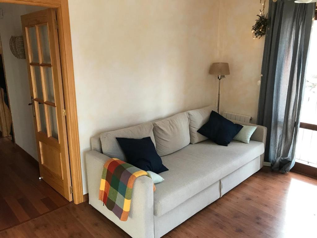 a white couch with pillows in a living room at Benasque Valley Apartment in Bisaurri