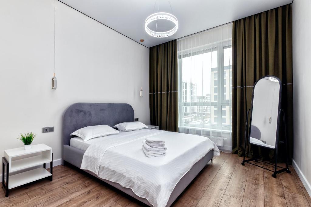 TaldykolʼにあるRaisson Ahotel Headliner E39-Khan Shatyrのベッドと大きな窓のある寝室