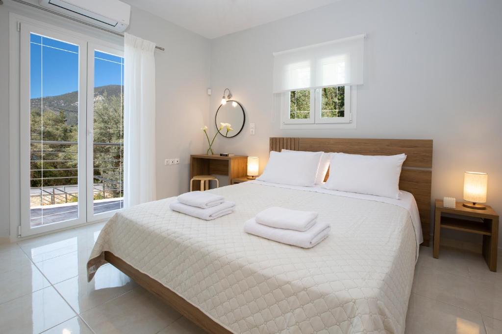 a bedroom with a large bed with two towels on it at Theros Apartment 2 in Yénion