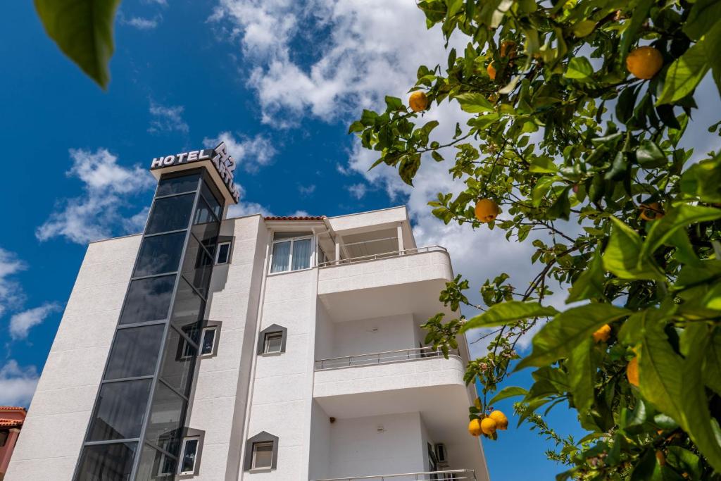 a building with an orange tree in front of it at Hotel Artur2 in Ksamil