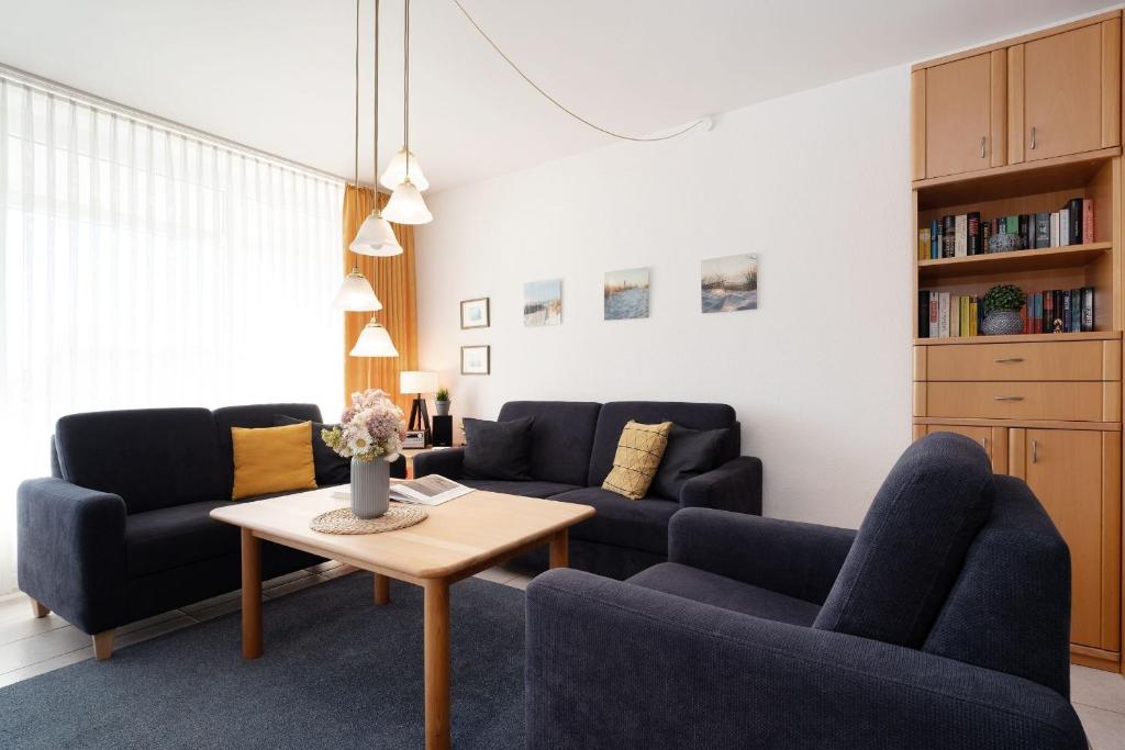 a living room with blue chairs and a table at Schützenweg 6 Ostseesonne in Kellenhusen