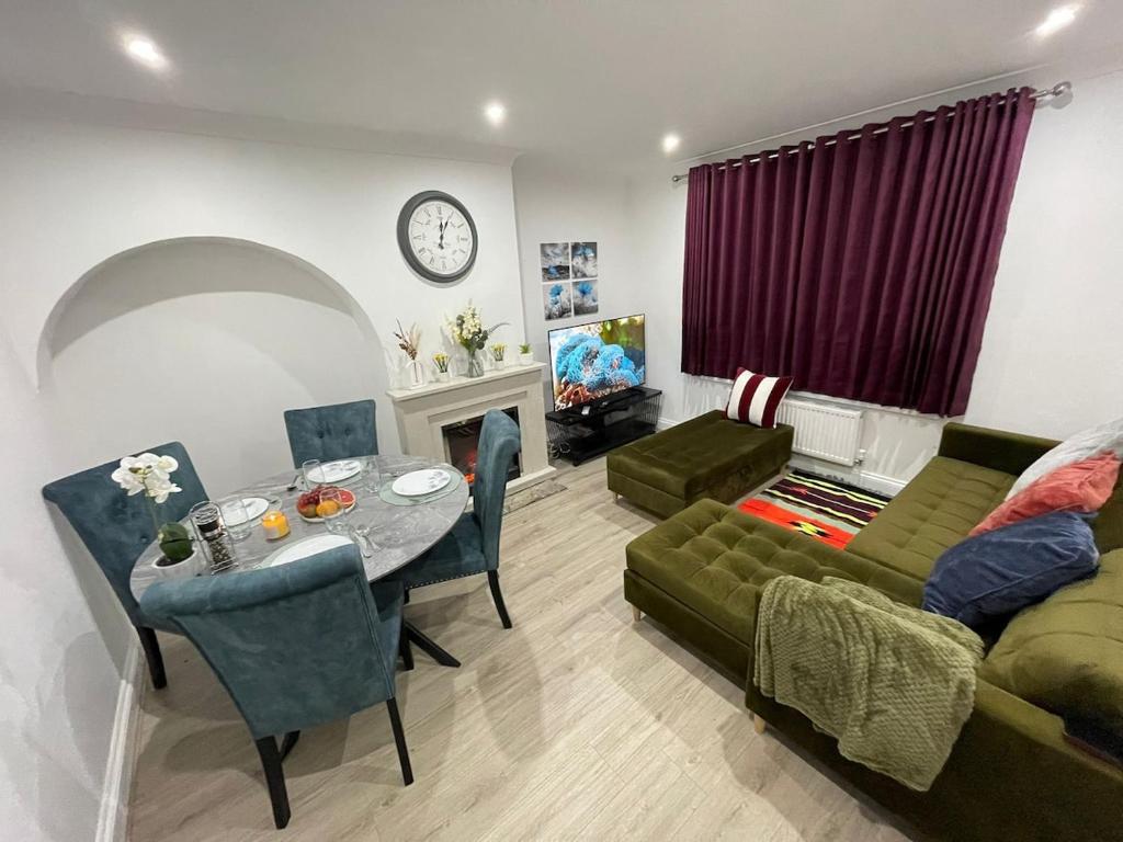 a living room with a green couch and a table at Peaceful 3 bedrooms house to rent in East London in Dagenham