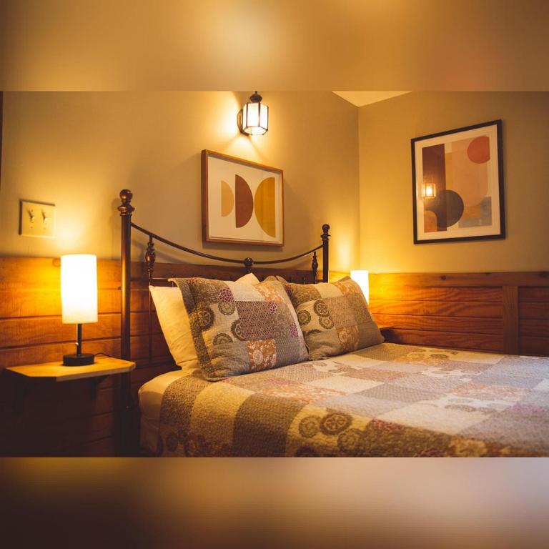 a bedroom with a bed with a lamp on it at A-Frame #06 - by The Chalets in Logan