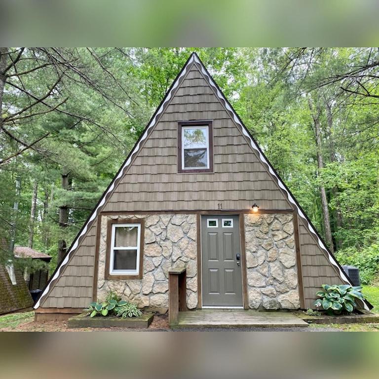 a small house with a pointed roof with a door at A-Frame #11 - by The Chalets in Logan