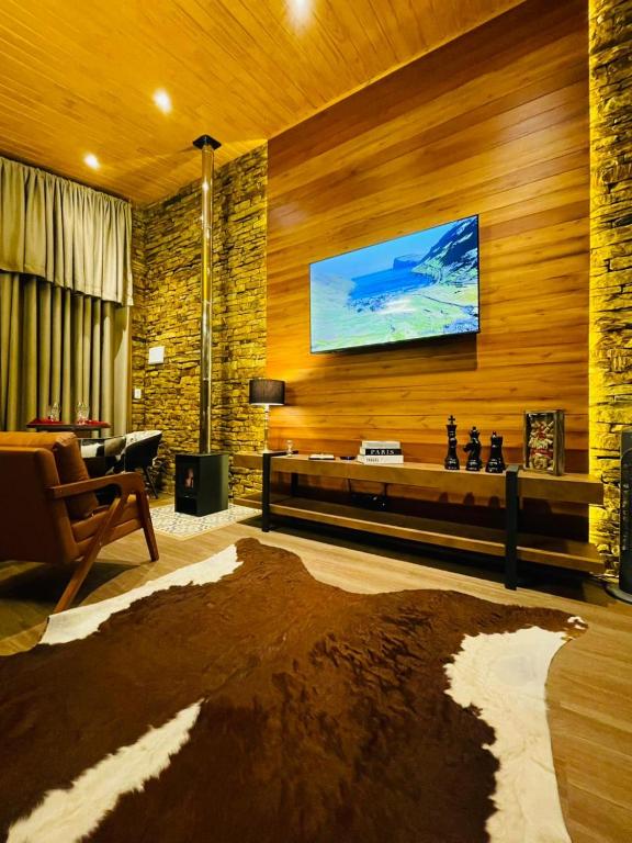 Una televisión o centro de entretenimiento en Requinte dos Pinhais Chalé Rubi