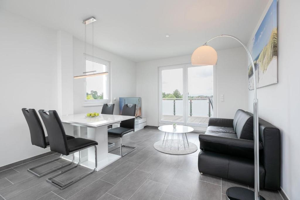 a living room with a table and black chairs at Brenkenhagener Weg 4 Wohnung 7 in Grömitz