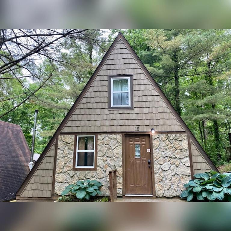 a small house with a large pointed roof at A-Frame #15 - by The Chalets in Logan