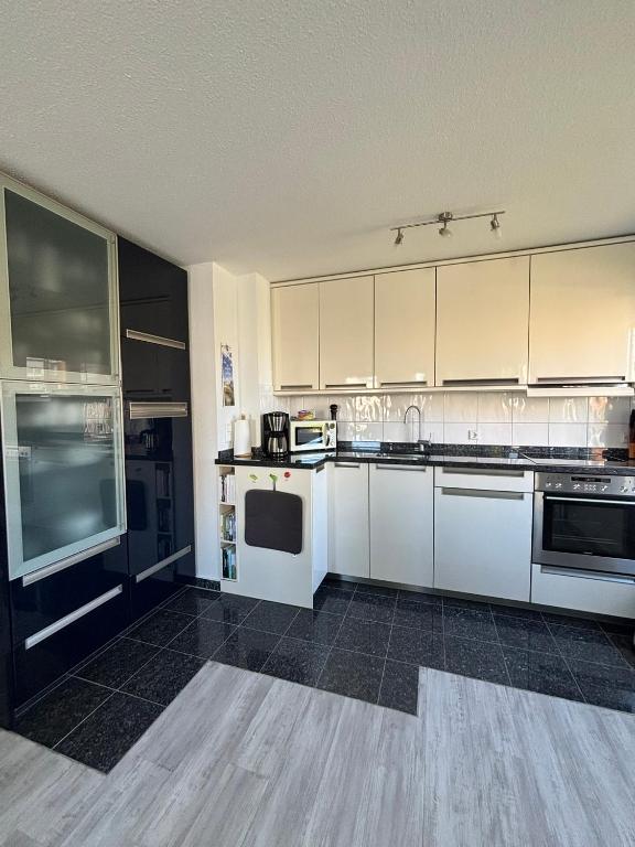 a kitchen with white cabinets and white appliances at Duhner Leuchturm, Ferienwohnung DL02 in Cuxhaven
