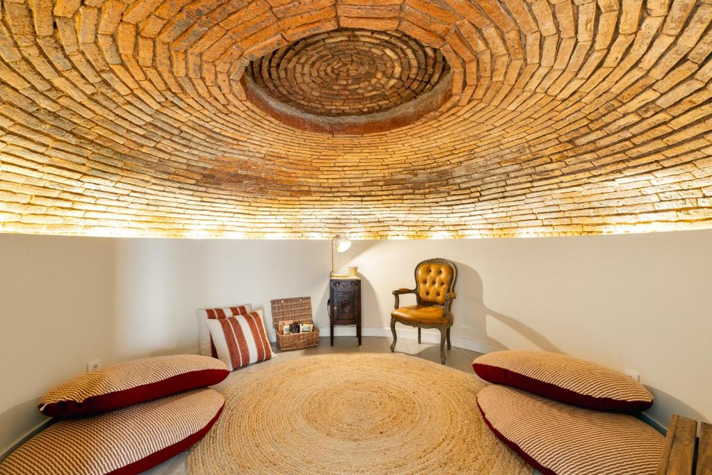 a bedroom with a round bed with a wooden ceiling at Amber and Rust Estremoz City House in Estremoz