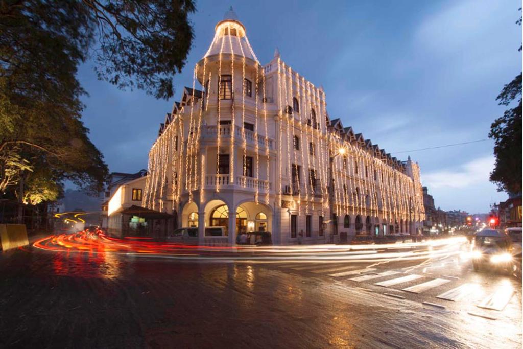 un gran edificio en una calle de la ciudad por la noche en Queen's Hotel, en Kandy