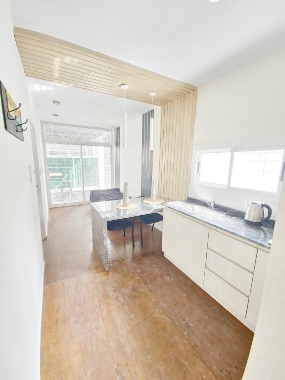 a kitchen with white cabinets and a table in it at Complejo Paso de los Andes in Rivadavia