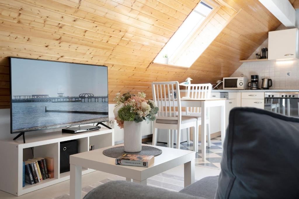 ein Wohnzimmer mit einem großen Flachbildfernseher in der Unterkunft Appartementhausanlage Tiemann Bernstein in Kellenhusen