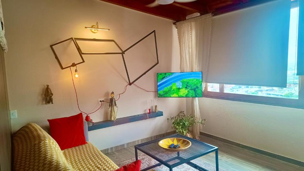 Una sala de estar con un sofá, una mesa y un televisor. en My Suite with views of Cali, en Cali