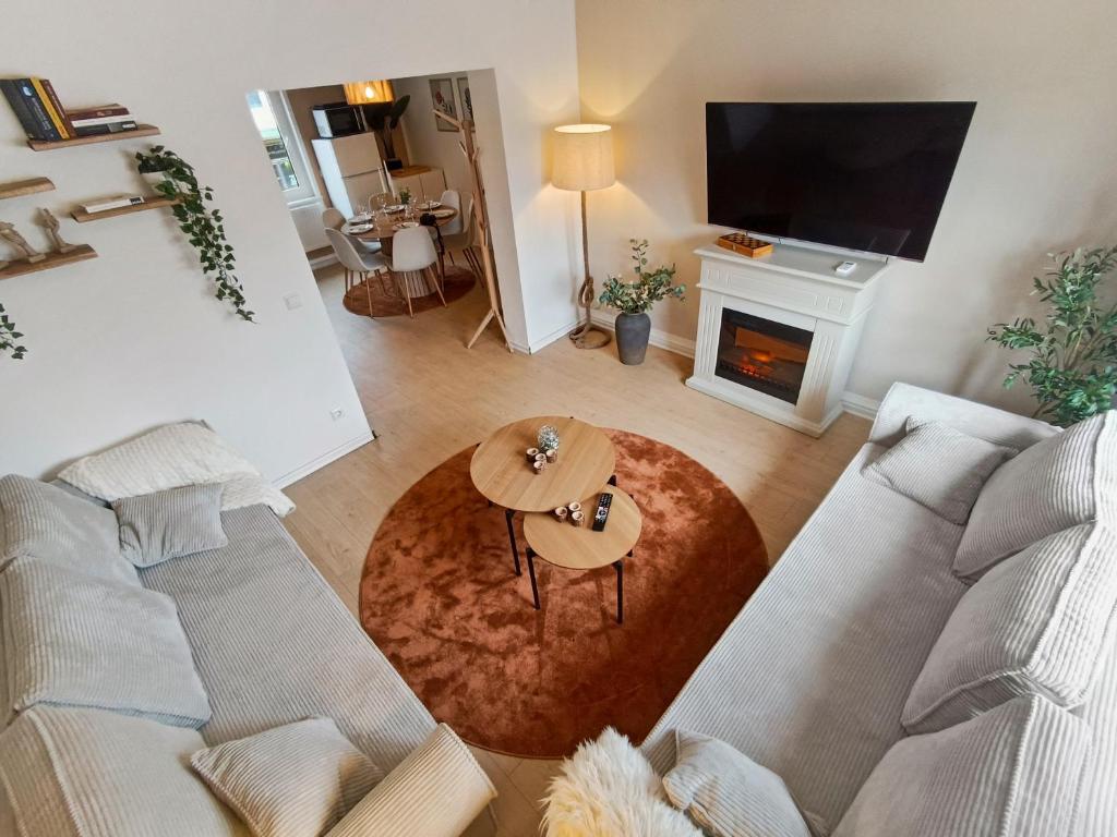 a living room with a couch and a fireplace at Lunaria Living I VW Tor 17 - Gemütlich - Home Office - Zentral - Parkplatz in Wolfsburg