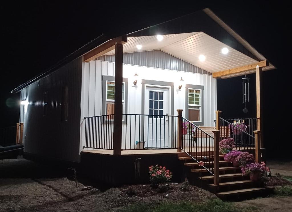a small white house with a porch at night at Granny Zola's Hideaway Bed & Breakfast in Saint Anthony