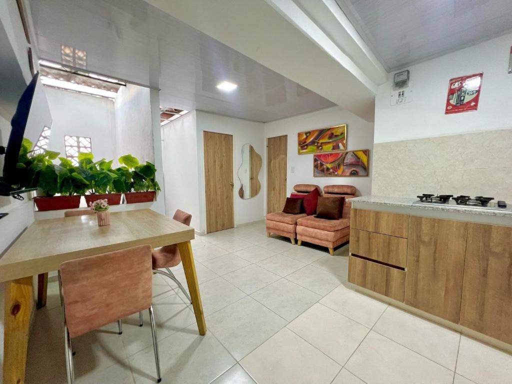 eine Küche und ein Wohnzimmer mit einem Tisch und einer Couch in der Unterkunft Increible Apto 10Min Base Aérea - Aquaparque Caña in Cali