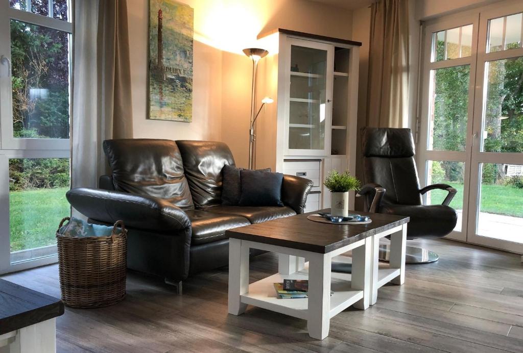 Una sala de estar con un sofá de cuero y una mesa. en Bürgermeister-Fox 44a An der Waterkant, en Neue Tiefe Fehmarn
