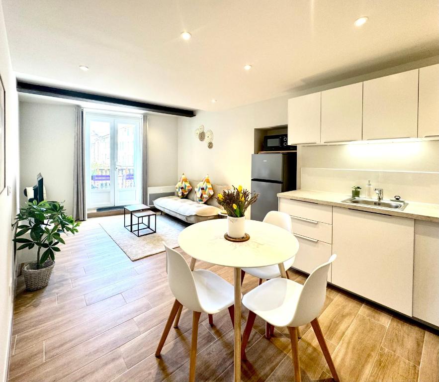 a kitchen and living room with a table and chairs at Le Cosy Bruey - Appartement Confort au Cœur du Centre Historique - Balcon & Patio in Orange