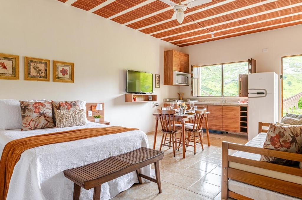 a bedroom with a bed and a kitchen with a table at Bonito Charmoso no Hotel Pedra do Rodeadouro Bonito PE in Bonito