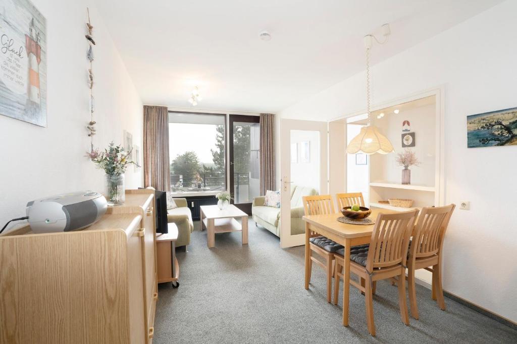 Una sala de estar con un sofá y un comedor. en Haus Meeresblick Findling, en Kellenhusen