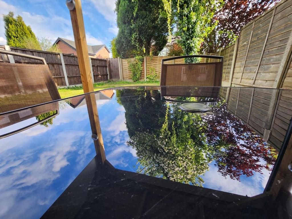un riflesso di una piscina d’acqua in un cortile di Newly Refurbished 3 Bedroom House with Lovely Garden a Bolton