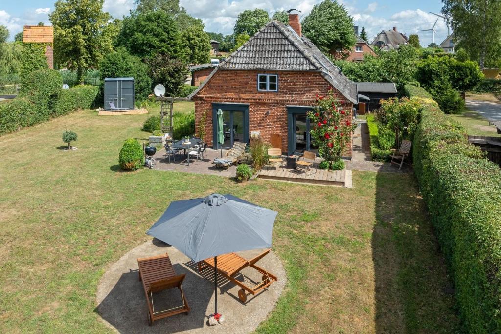 una casa con un paraguas en el patio en Landhaus Auszeit, en Rüting