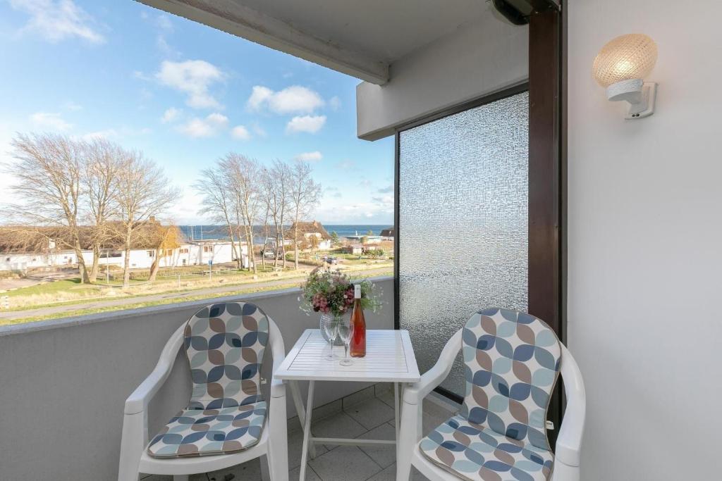 a balcony with a table and two chairs and a window at Haus Vier Jahreszeiten De Lütte in Dahme