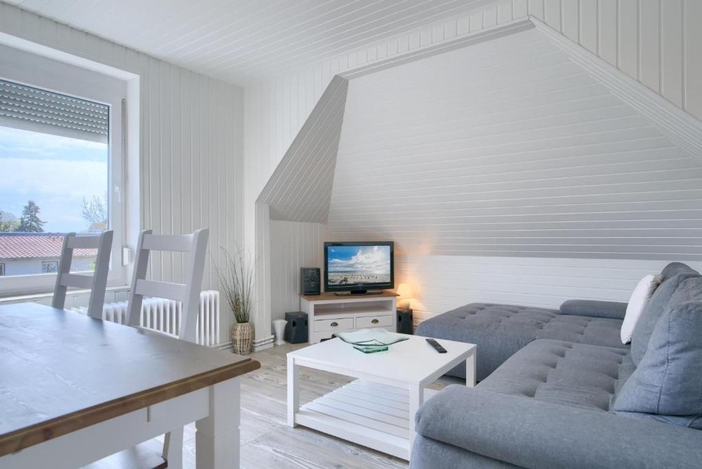 a living room with a couch and a tv at Seestraße 30a In der Mühle in Dahme