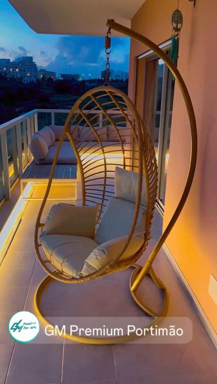 a rattan swing chair on the balcony of a house at GM Premium Portimão in Portimão