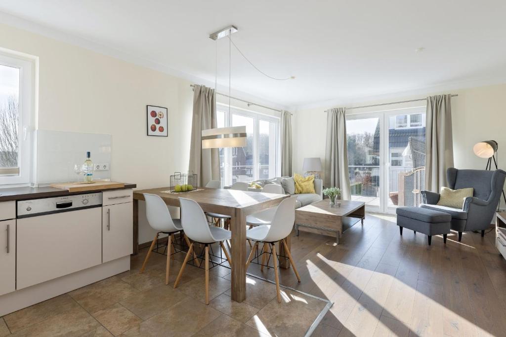 a kitchen and living room with a table and chairs at Baltic Sea Lodge Küstenglanz in Scharbeutz