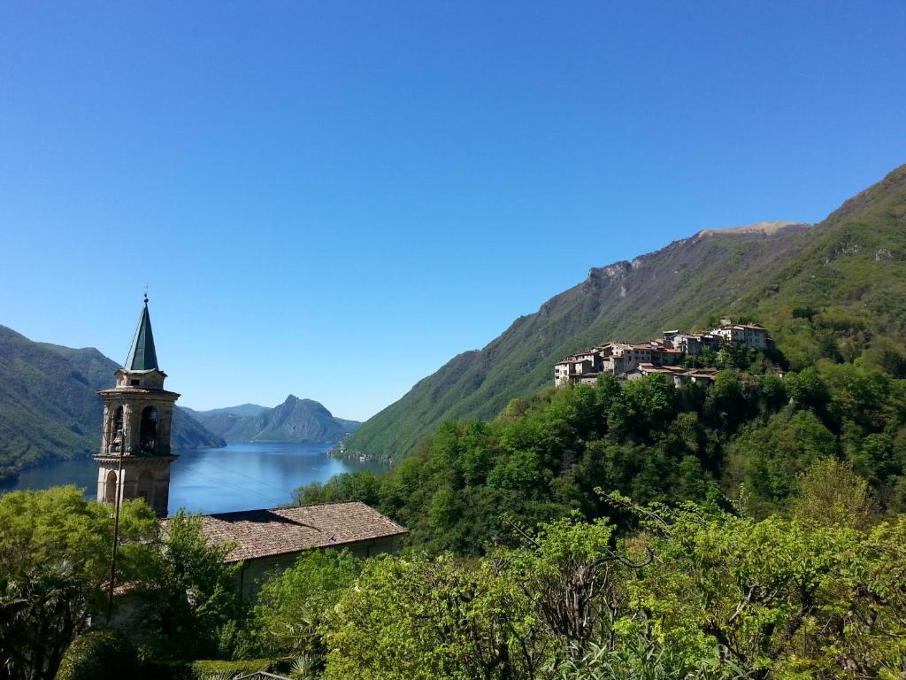 eine Kirche auf einem Hügel neben einem Wasserkörper in der Unterkunft Le tre sorelle in Valsolda